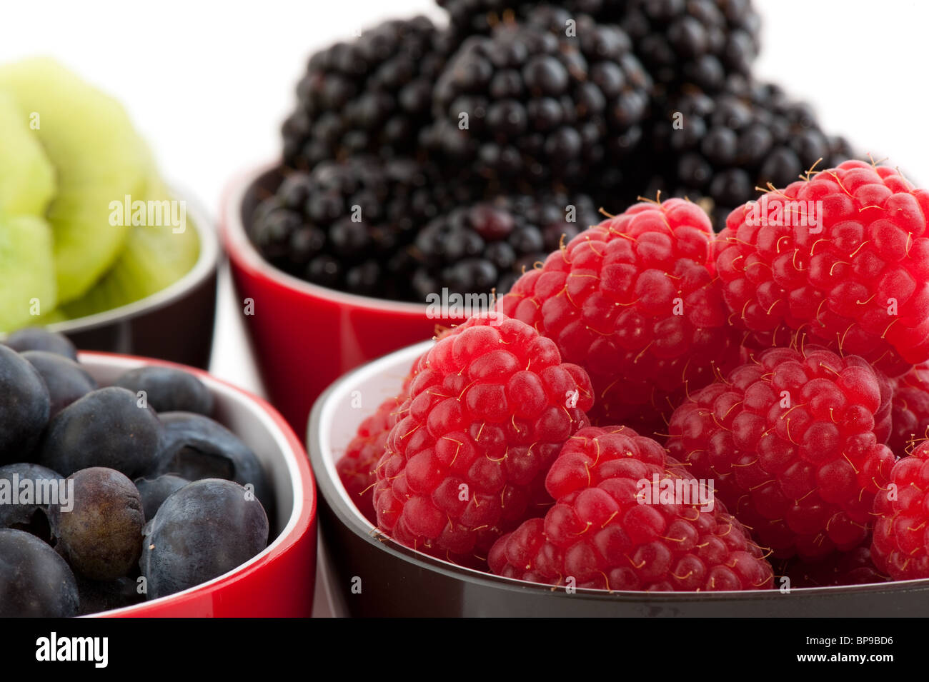 Mischung aus Sommer Obst in schwarzen und roten Schalen Stockfoto