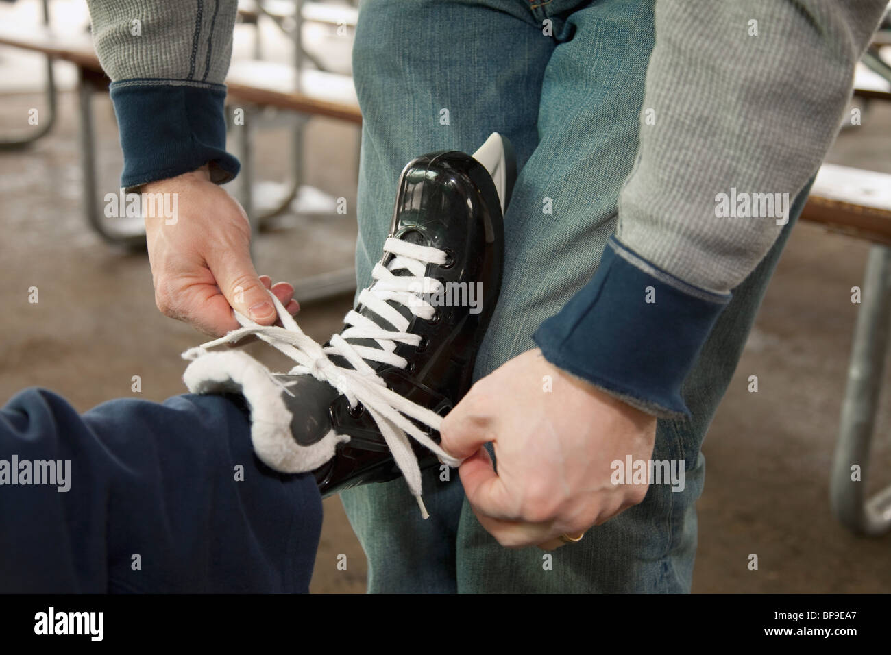 Edmonton, Alberta, Kanada; ein Vater, einen Sohn helfen setzen auf Schlittschuhen Stockfoto