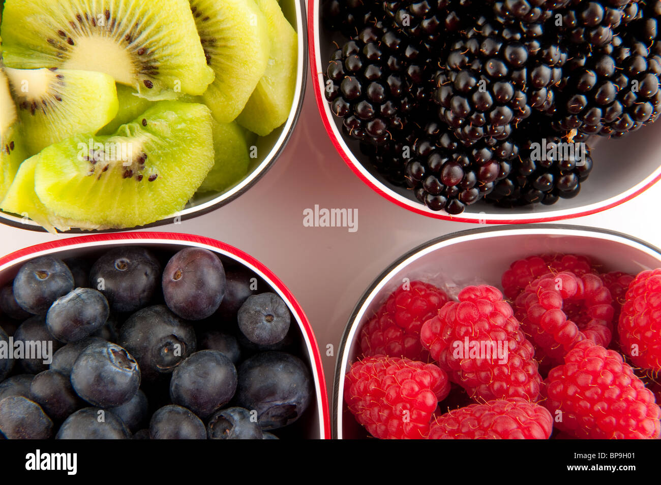 Mischung aus Sommer Obst in schwarzen und roten Schalen Stockfoto