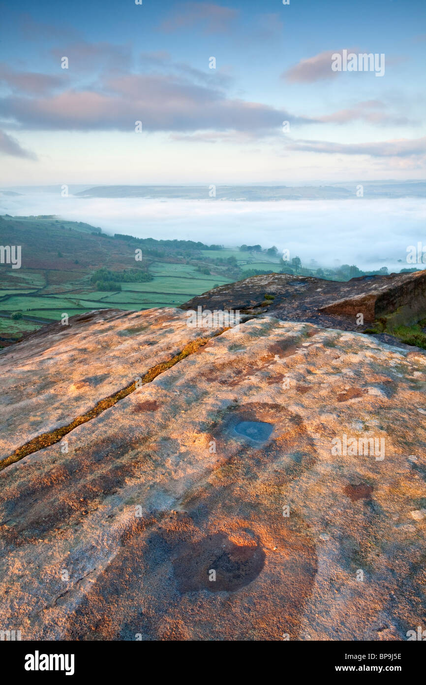 Eine neblige betrachtet Frühlingsmorgen vom Curbar Rand mit Blick auf das Tal der Nebel gefüllt über Dorf Calver in Derbyshire Stockfoto
