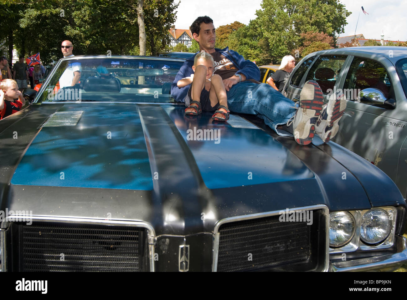 Amerikanische Oldtimer & ihre Besitzer, Vater & Sohn saß auf Kapuze / Mütze Stockfoto