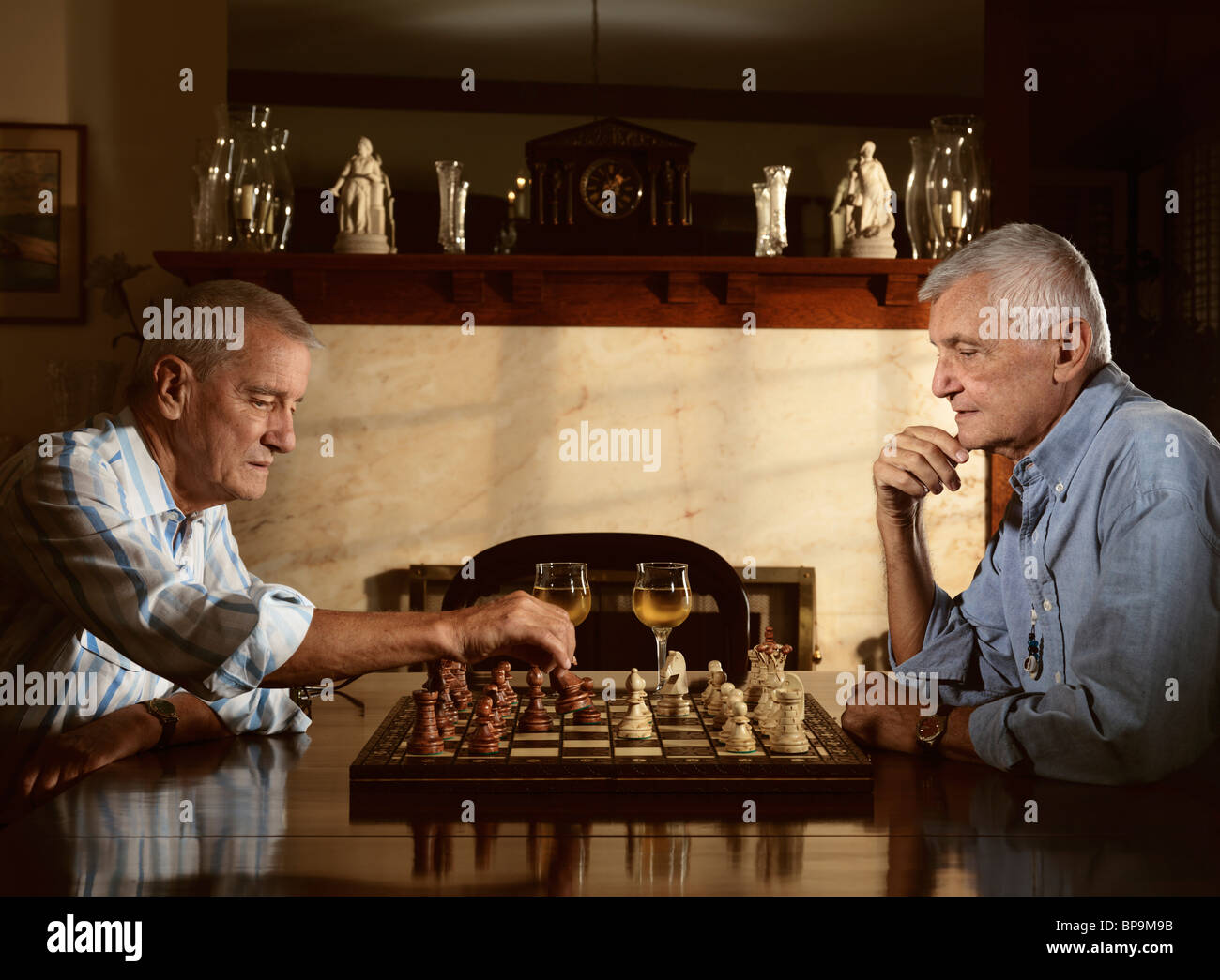 Zwei Senioren genießen Sie am Abend eine Partie Schach Stockfoto