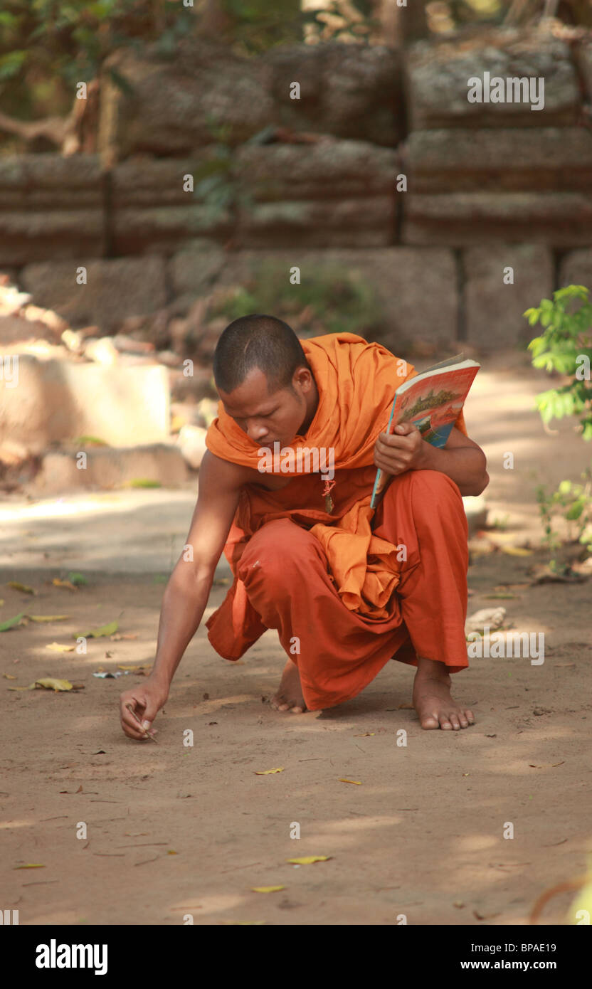 Buddhistischer Mönch ist in den Sand schreiben. Stockfoto