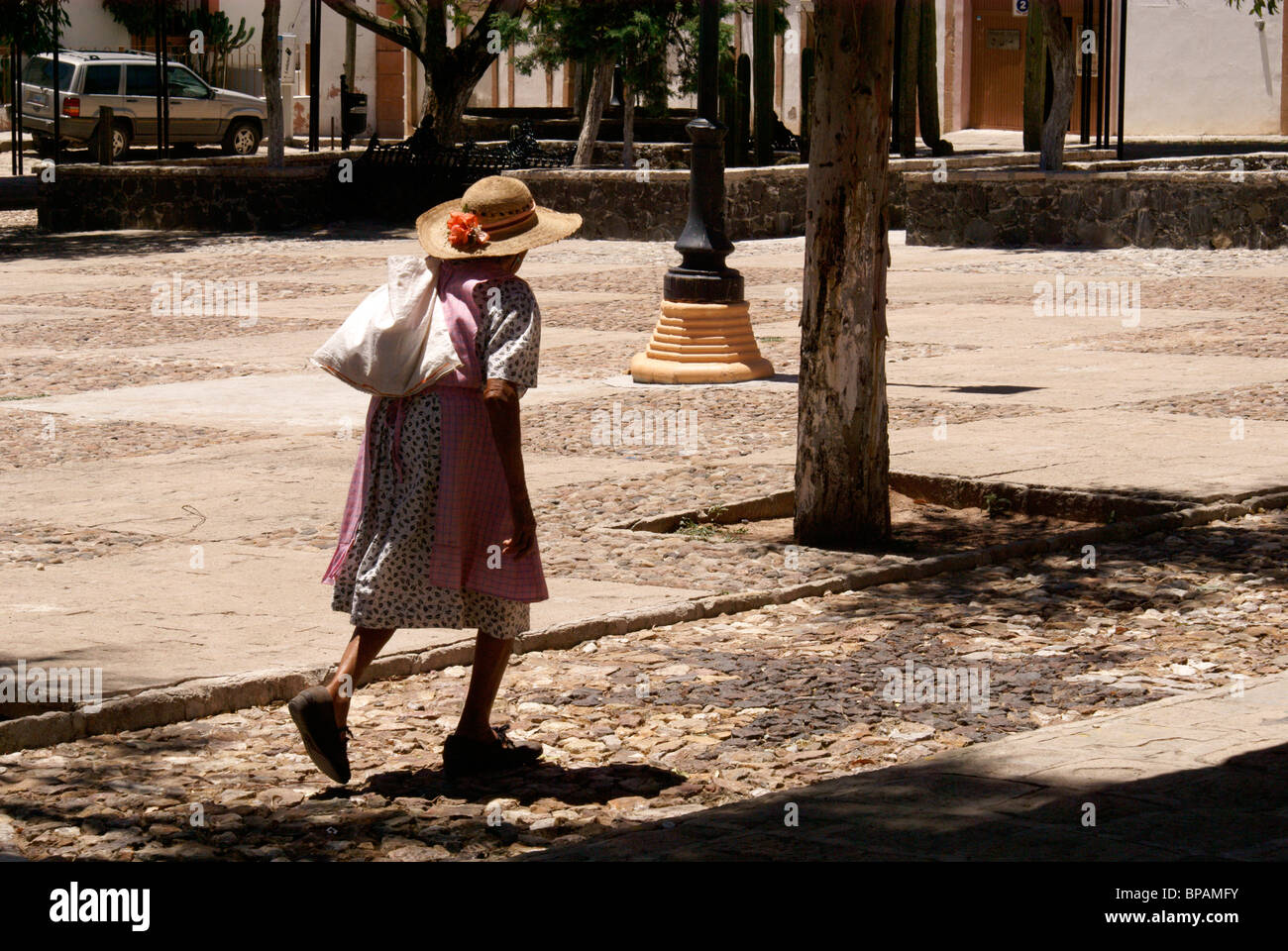 Ältere Frau Überqueren einer Plaza im 19. Jahrhundert Bergbaustadt Mineral de Pozos, Guanajuato, Mexiko Stockfoto