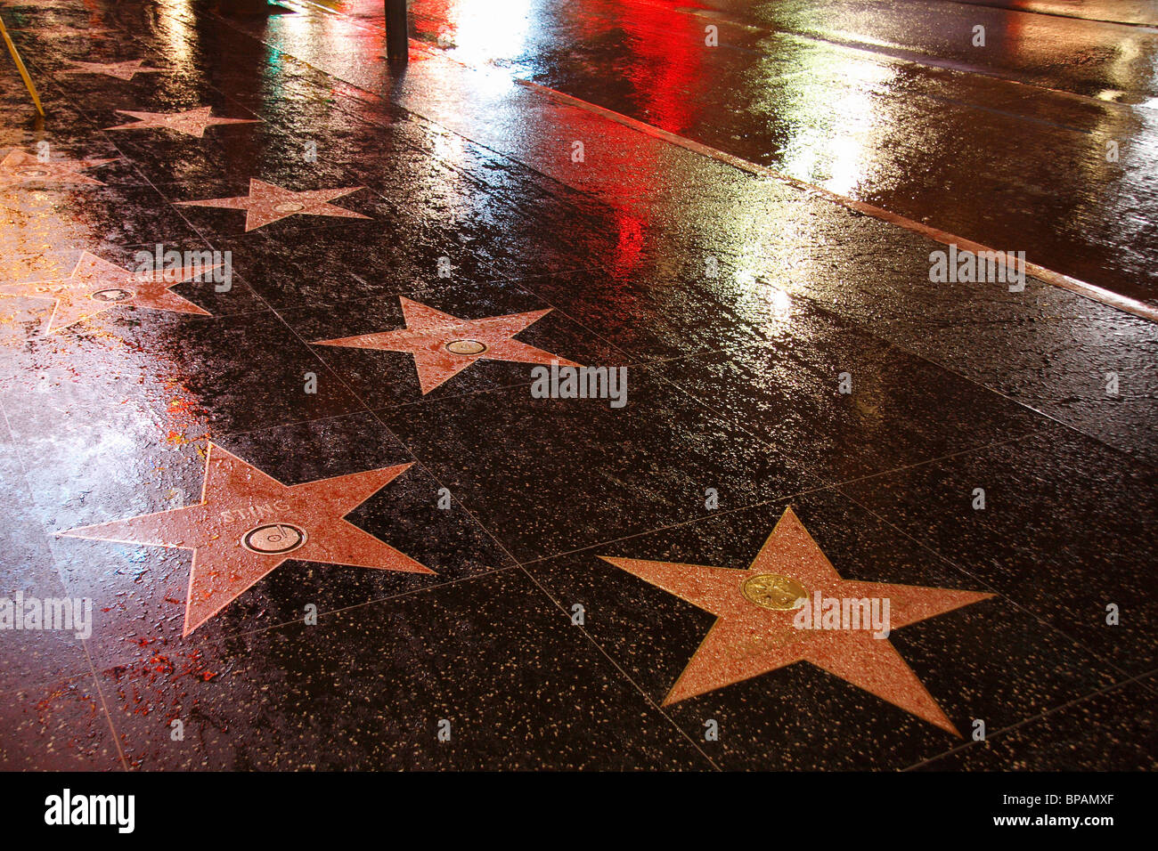 Hollywood Walk of Fame Boulevard nass mit Regen und Reflexionen in der Nacht Stockfoto