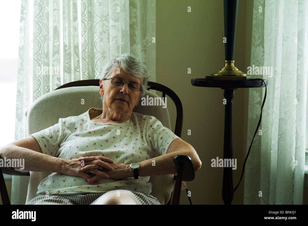 Alte Frau schlafen im Wohnzimmer Stuhl. Stockfoto