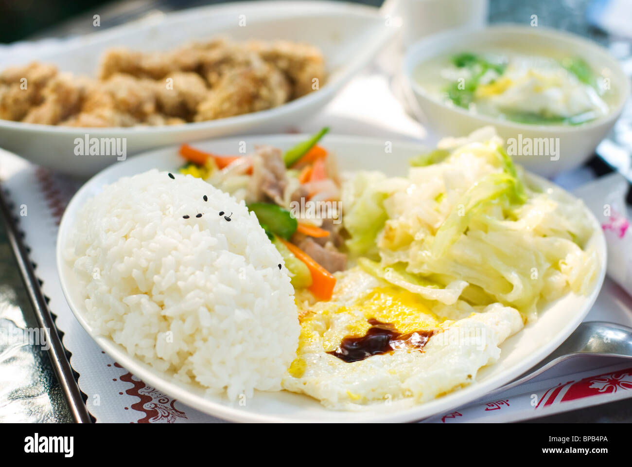 Köstliche Satz von Mittagessen. Chinesisches Essen mit Reis, Ei, Kohl Gemüse, gebratenes Huhn und Suppe auf dem Tisch. Stockfoto