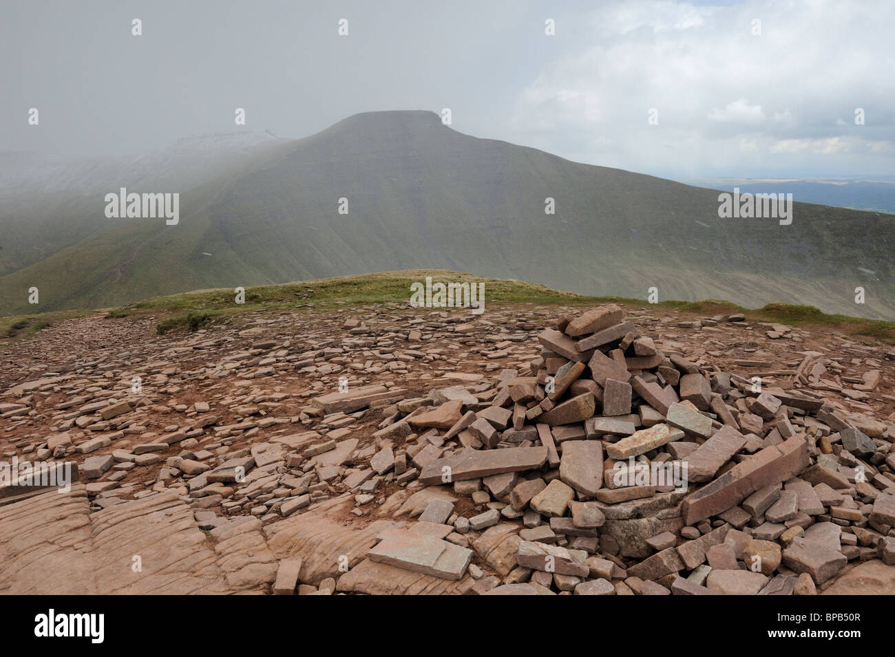 Der Gipfel Cairn auf Fan Y groß mit Cribyn und Pen Y Fan sichtbar in der Ferne. Brecon Beacons, Wales. Stockfoto