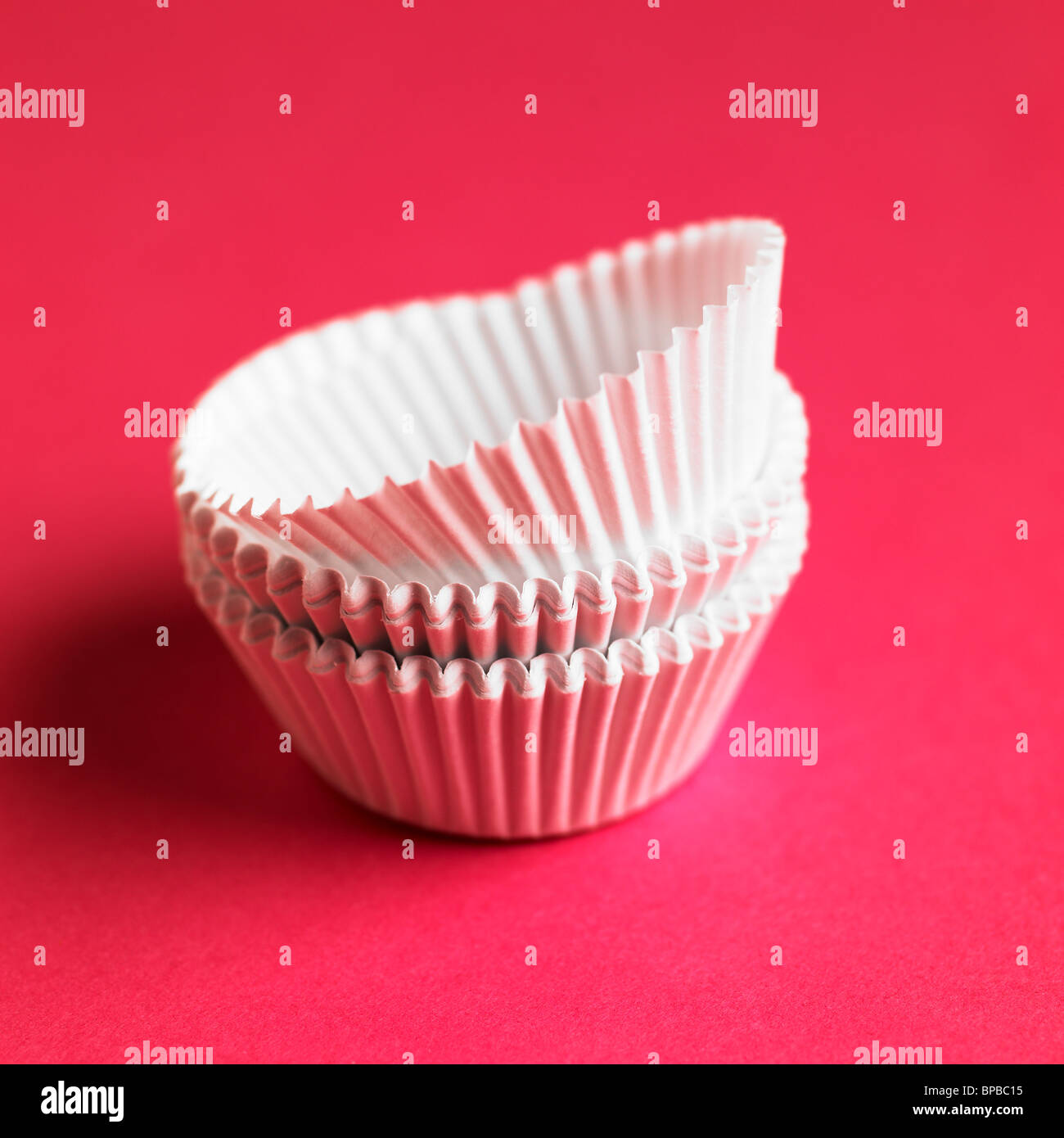 Leere weiße Kuchen Fällen auf einem rosa Hintergrund Stockfoto