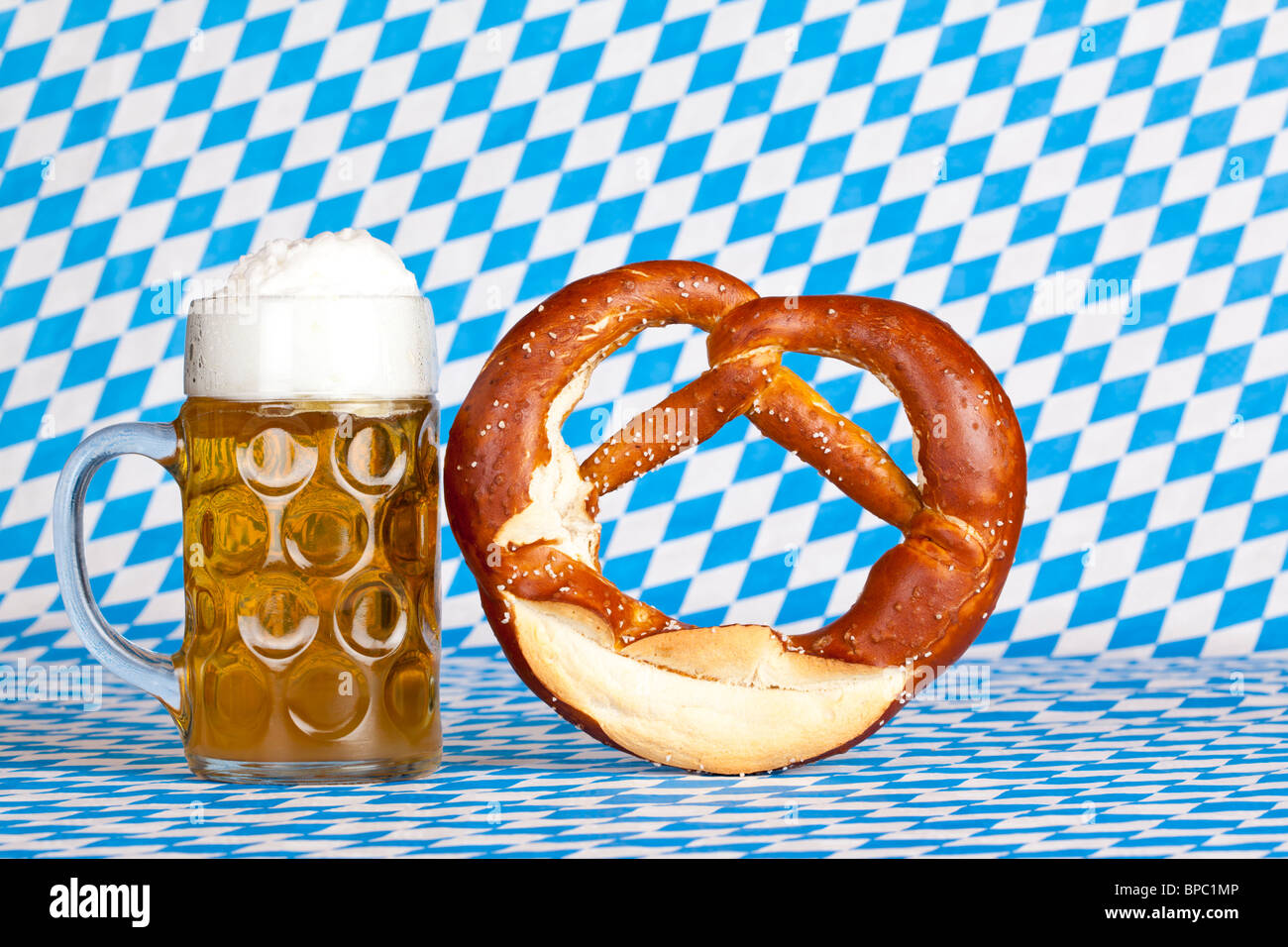 Oktoberfest Bierkrug mit Brezel und bayerische Flagge im Hintergrund ...