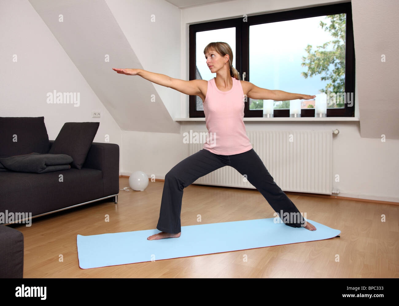 Junge Frau Yogaübungen zu Hause. Stockfoto