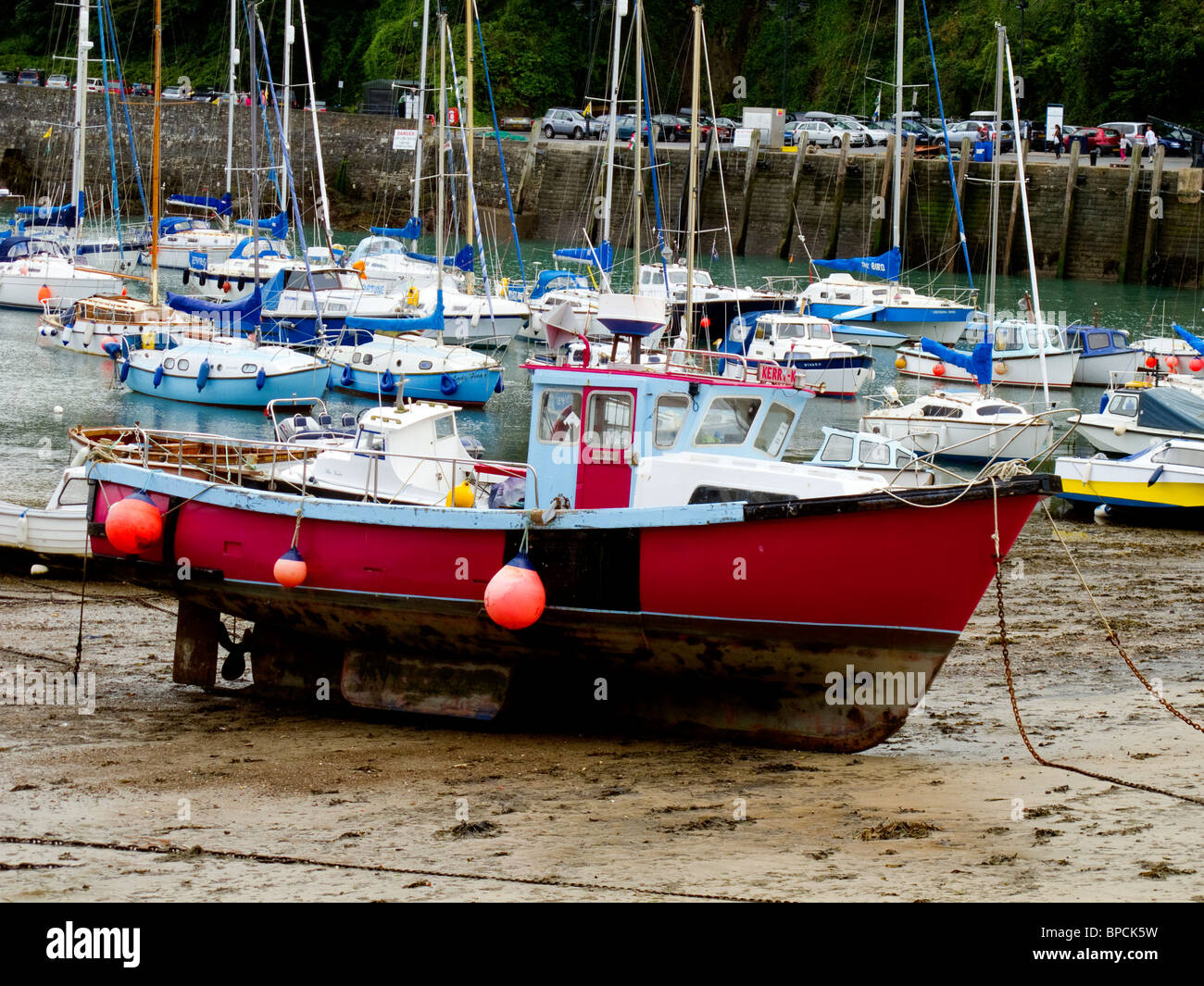 Eine rote geschälten Fischerboot liegt auf dem kleinen Strand in Ilfracombe Hafen bei Ebbe Stockfoto