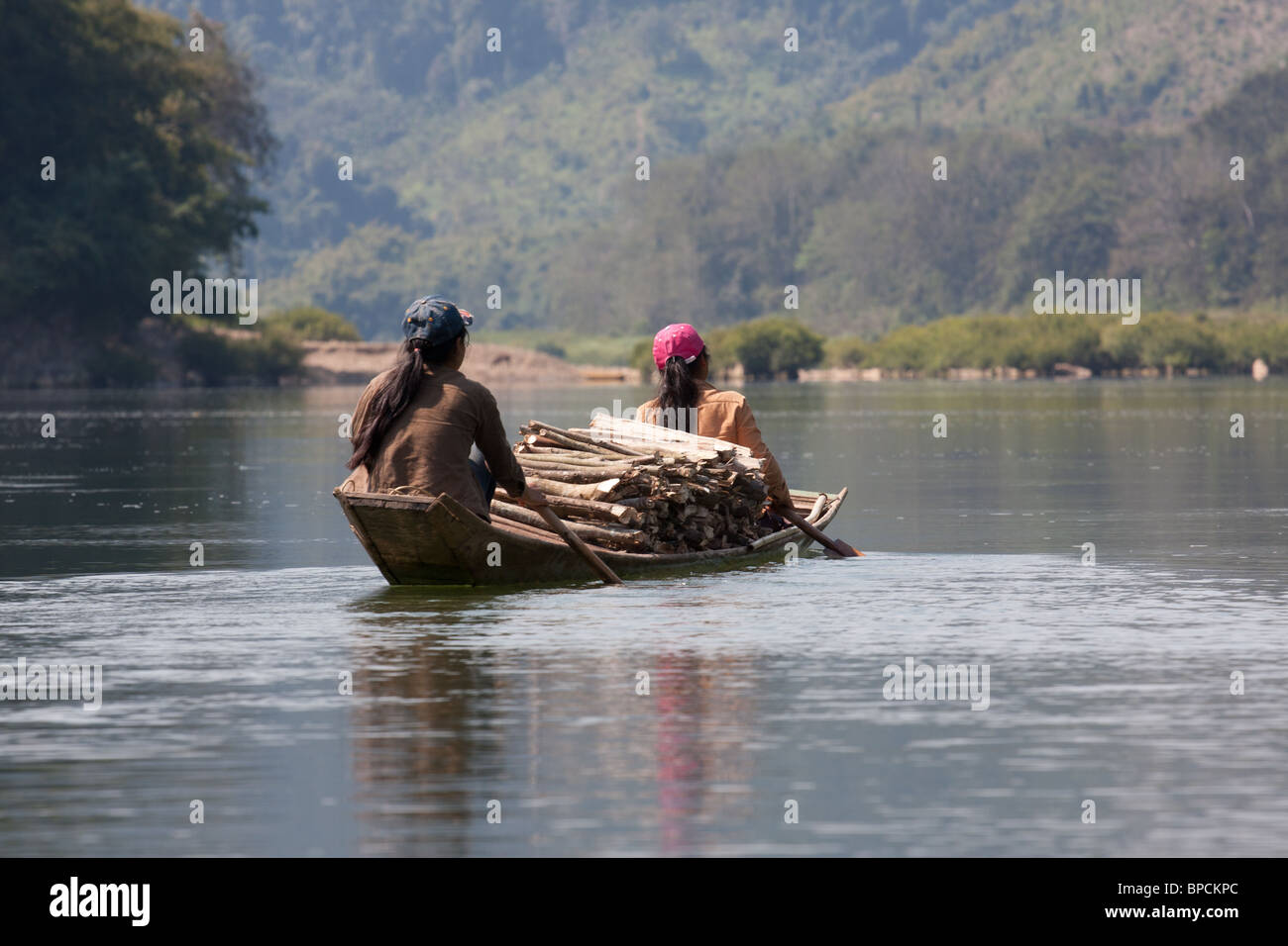 zwei Frauen paddeln Sie beladen mit Holz auf dem Nam Ou Fluss, Laos Stockfoto