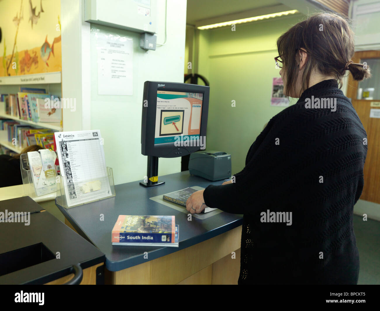 Ein Teenager-Mädchen mit einer automatisierten Bibliothek Management System (LMS) in ein Media Center, England Stockfoto