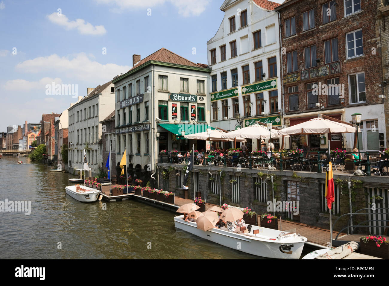 Graslei Website, Gent, Ost-Flandern, Belgien. Touristen in Sightseeing-Boot am Fluss Leie mit Kai Café in der Altstadt Stockfoto