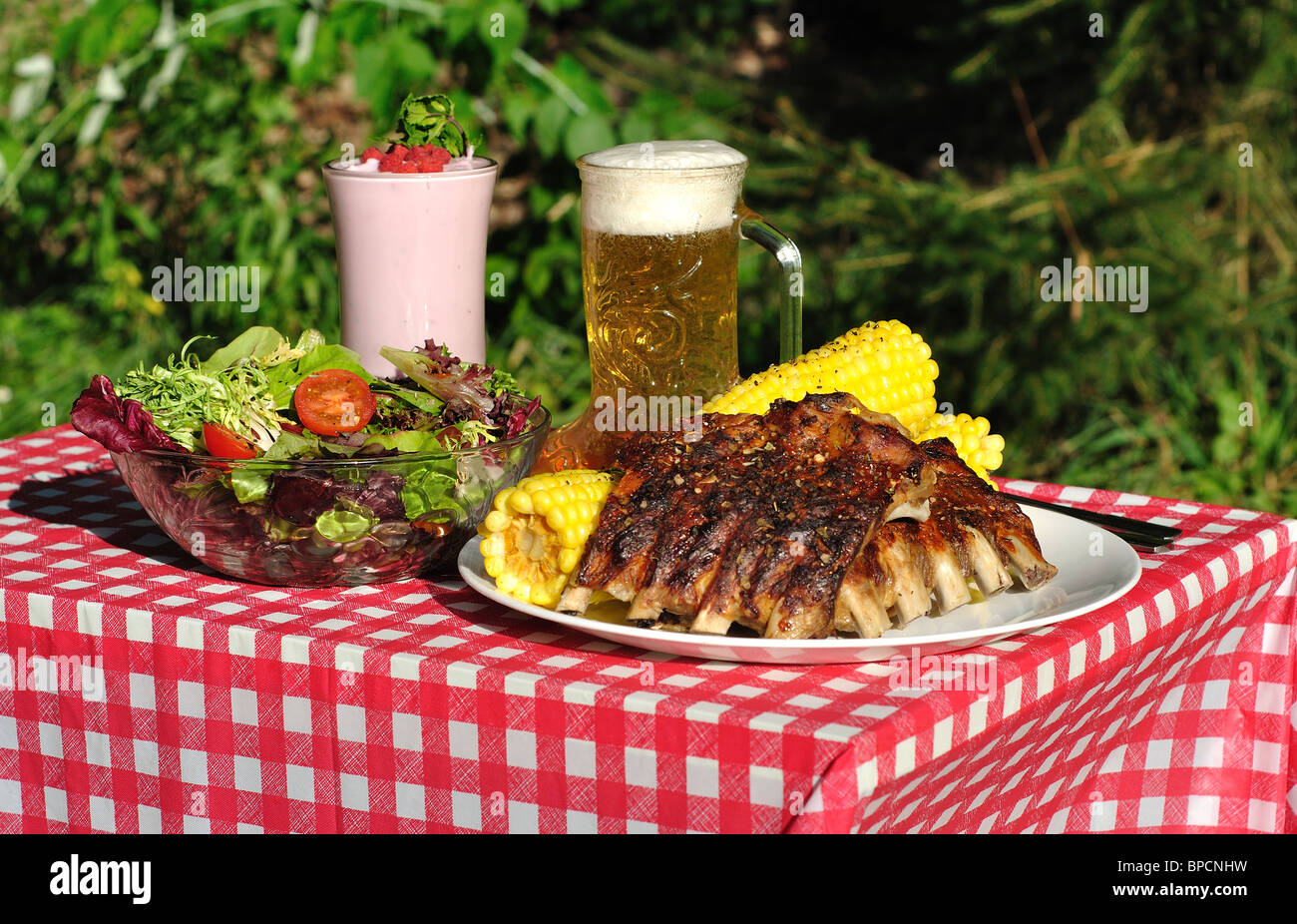 Rippen Feldsalat Bier Joghurt auf rote und weiße Tischdecke Stockfoto