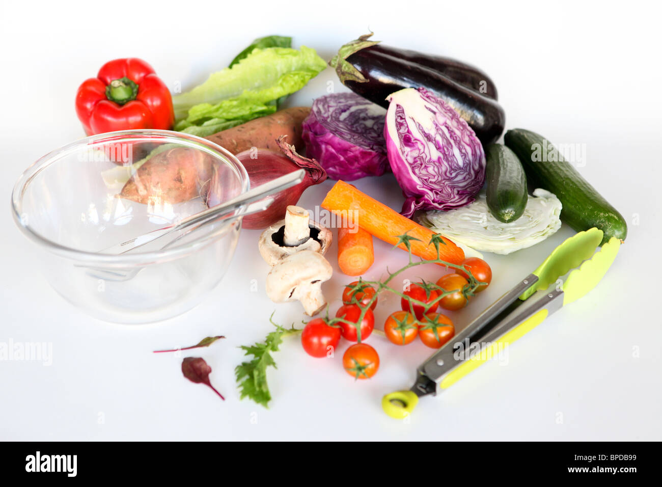 Frisches Obst und eine leere Schüssel. Völlig ungeschnitten Salatzutaten auf weißem Hintergrund Stockfoto