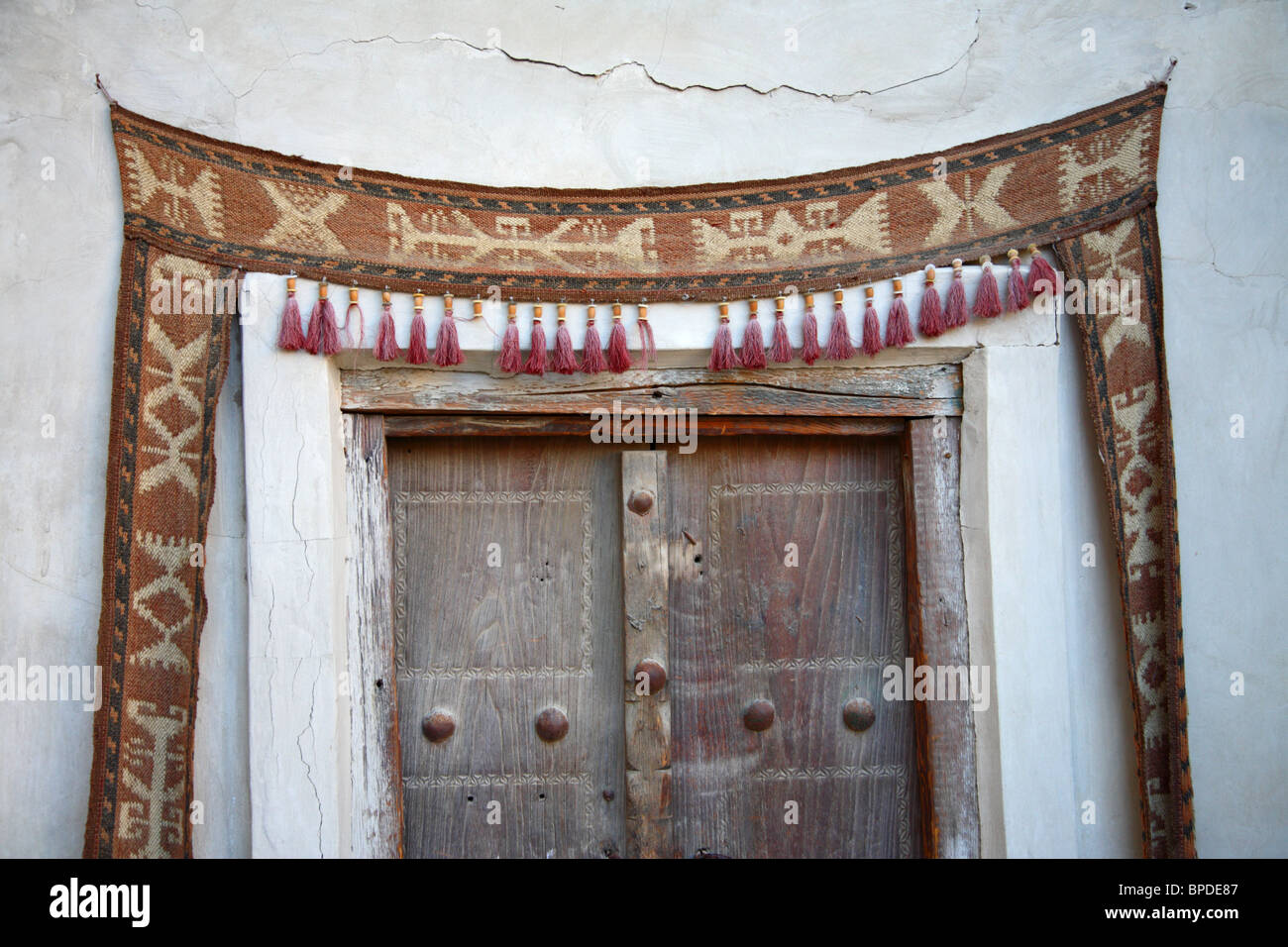 Eine Tür mit einem gewebten Stoff Dekoration mit Quasten in Bokhara-Markt in Bukhara, Uzbekistan. Stockfoto