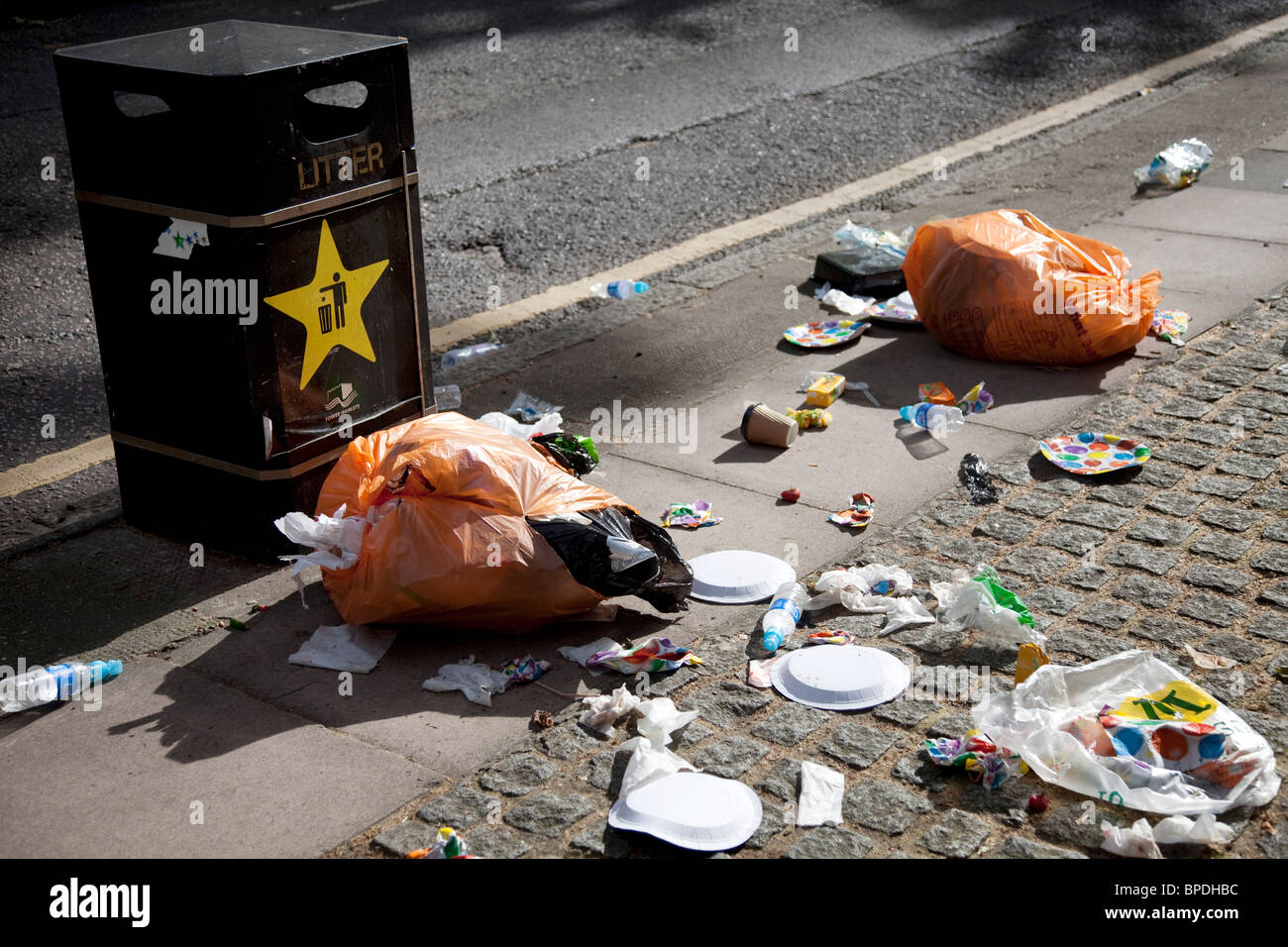 Müll auf der Straße. Wurf auf einer großen Skala neben einem Mülleimer. Stockfoto