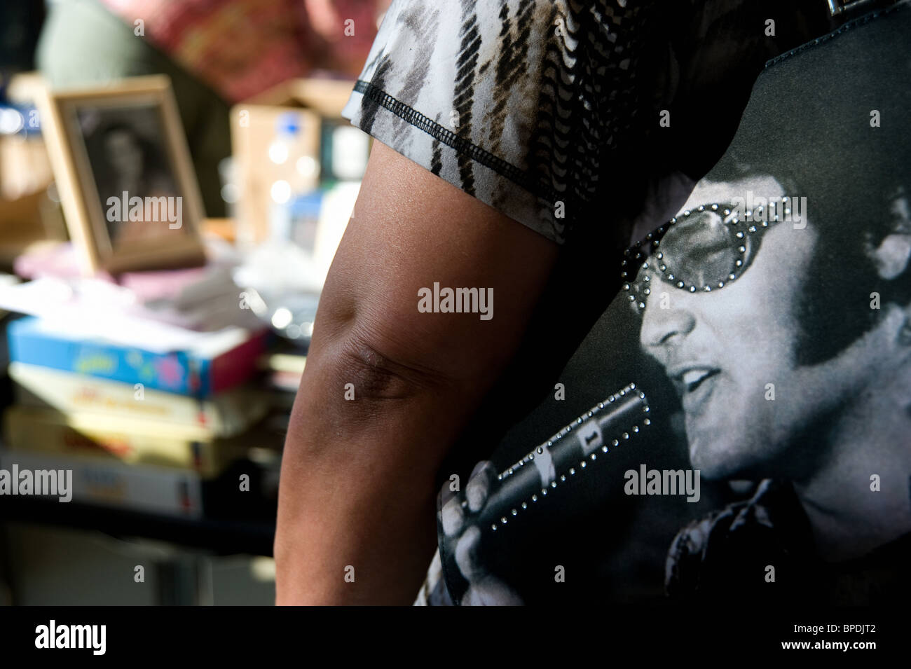 Frau trägt eine Tasche mit einem Bild von Elvis Presley drauf. Stockfoto