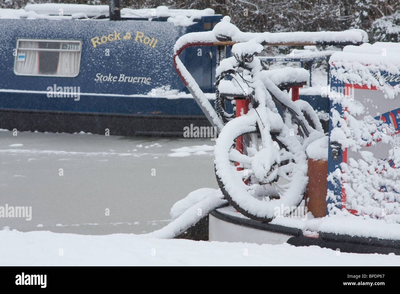 Narrowboats stecken in einem gefrorenen Kanal und mit Schnee bedeckt Stockfoto