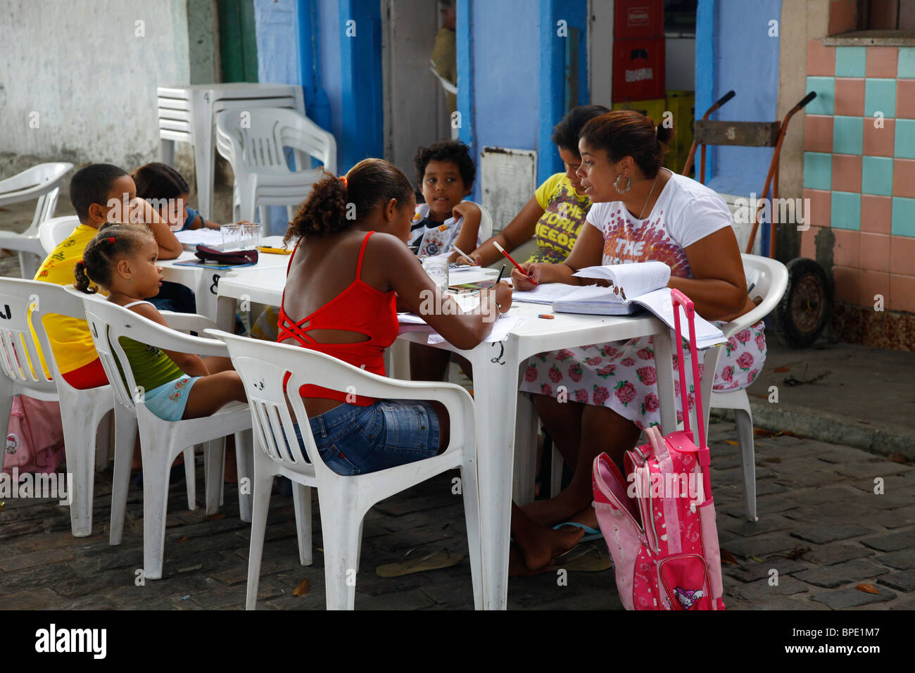 Frauen, die Hausaufgaben der Schule mit ihren Kindern in der Stadt von Itaparica, Insel Itaparica in der Nähe von Salvador, Bahia, Brasilien. Stockfoto