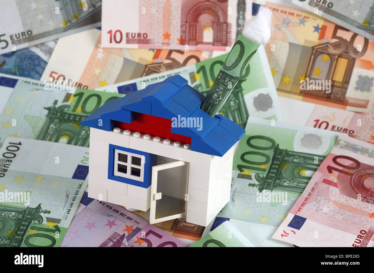 Ein Haus mit einem Schornstein der 100-Euro-Schein als Symbol der Einsparungen von LEGO-Steinen gebaut Stockfoto
