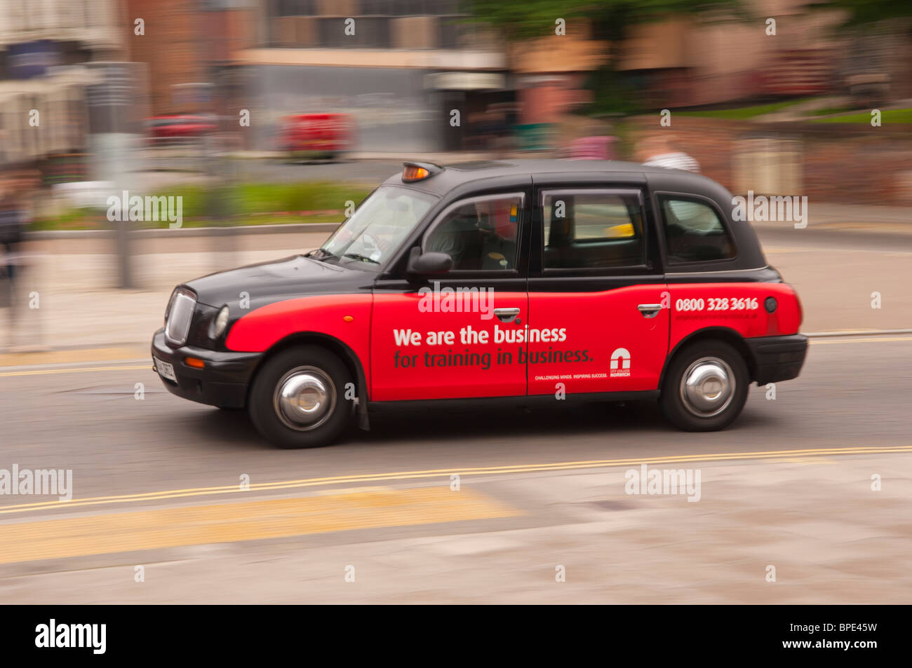 Ein schwarzes Londoner Taxi cab Fahrt durch die Stadt und zeigt Bewegung in Norwich, Norfolk, England, Großbritannien, Uk Stockfoto