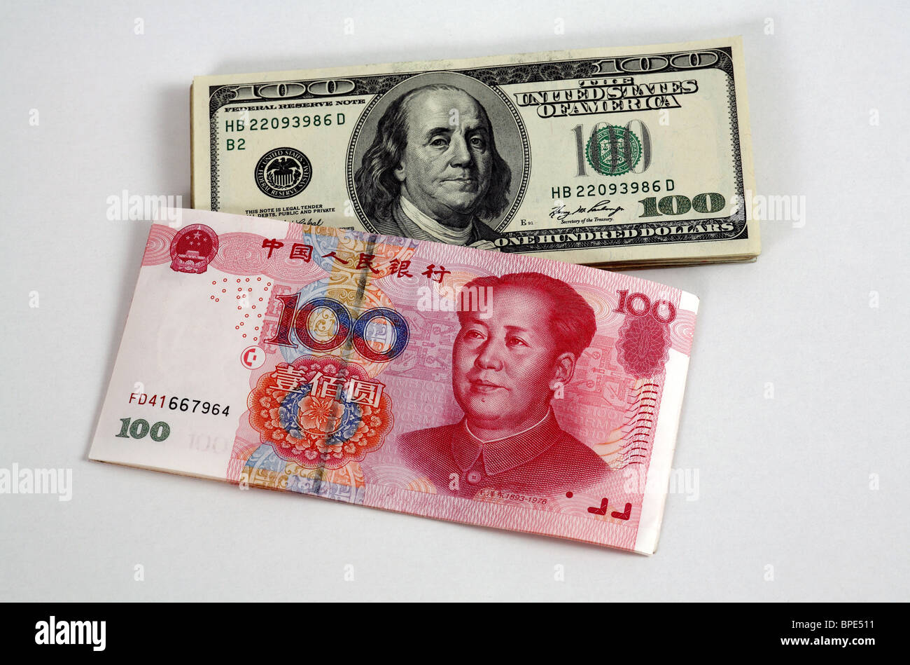 100-Dollar- und 100-Renminbi Yuan Banknoten Stockfoto