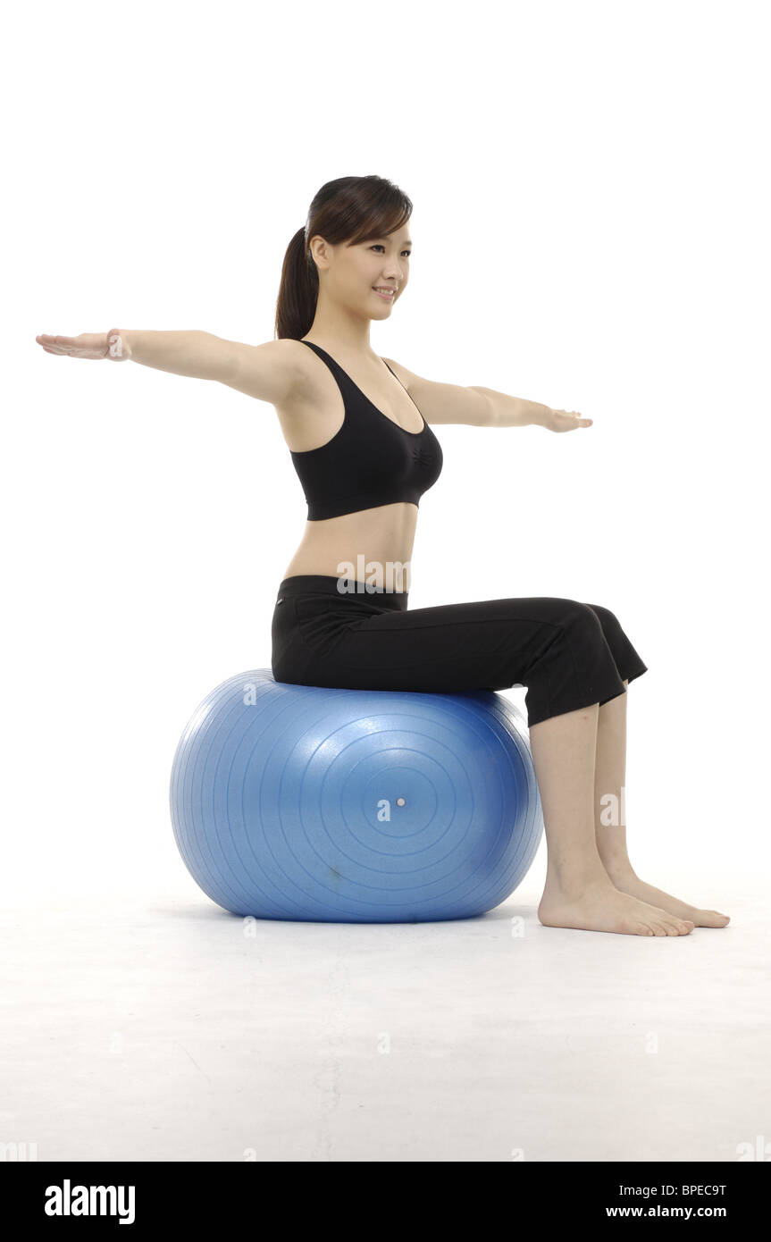junge Frau praktizieren Yoga auf Gymnastikball Stockfoto