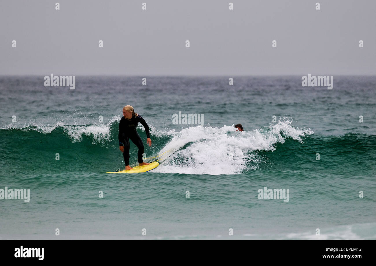 Eine Surferin am Sennen in Cornwall. Stockfoto