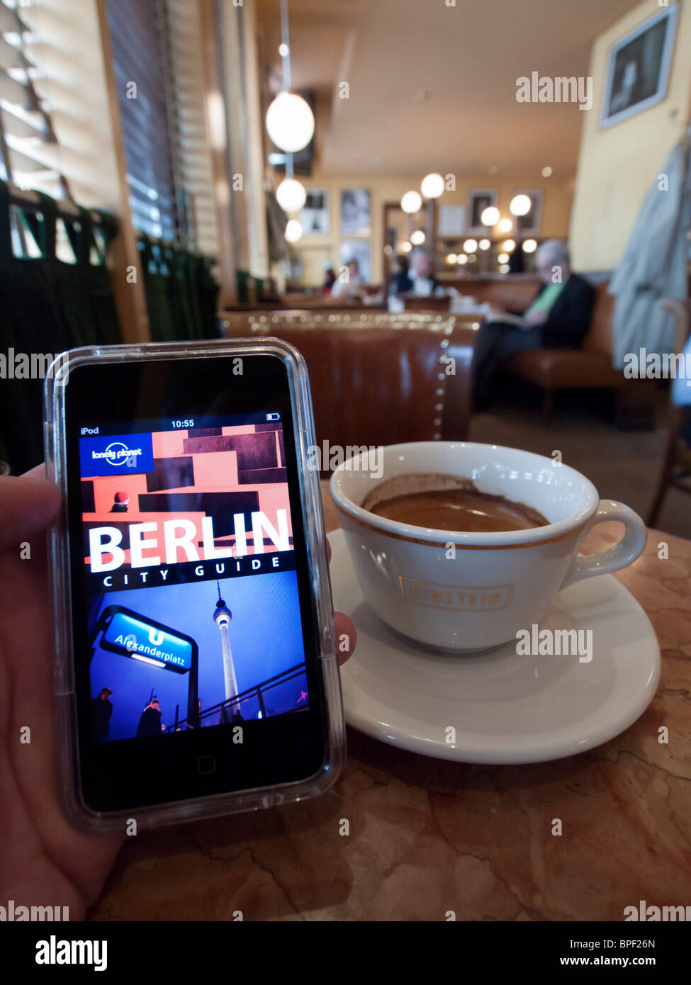 Tourist mit e-Book Reiseführer für Berlin im berühmten Café Einstein unter Den Linden in Berlin Deutschland Stockfoto