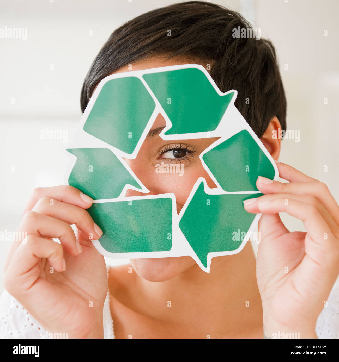 Gemischte Rassen Frau mit recycling-Symbol vor Gesicht Stockfoto