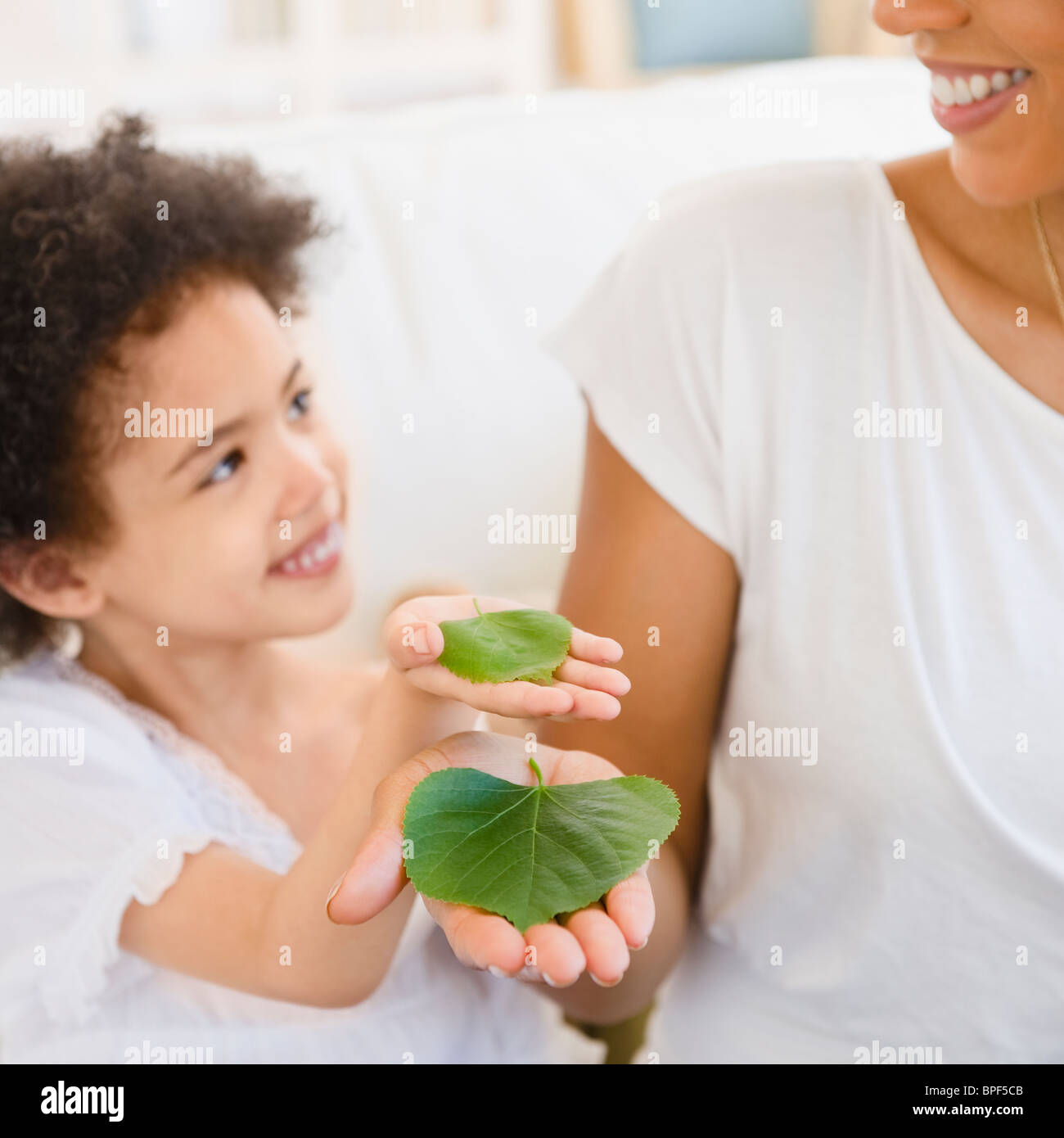 Mutter und Tochter hält grüne Blätter Stockfoto