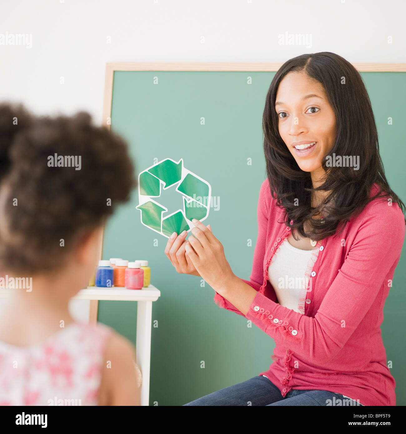 Lehrer zeigt Recyclingsymbol für Schüler Stockfoto