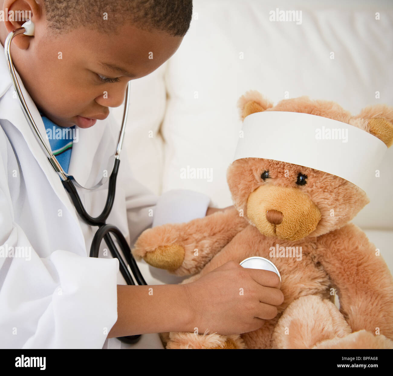 African American Boy spielen Arzt mit Teddybär Stockfoto