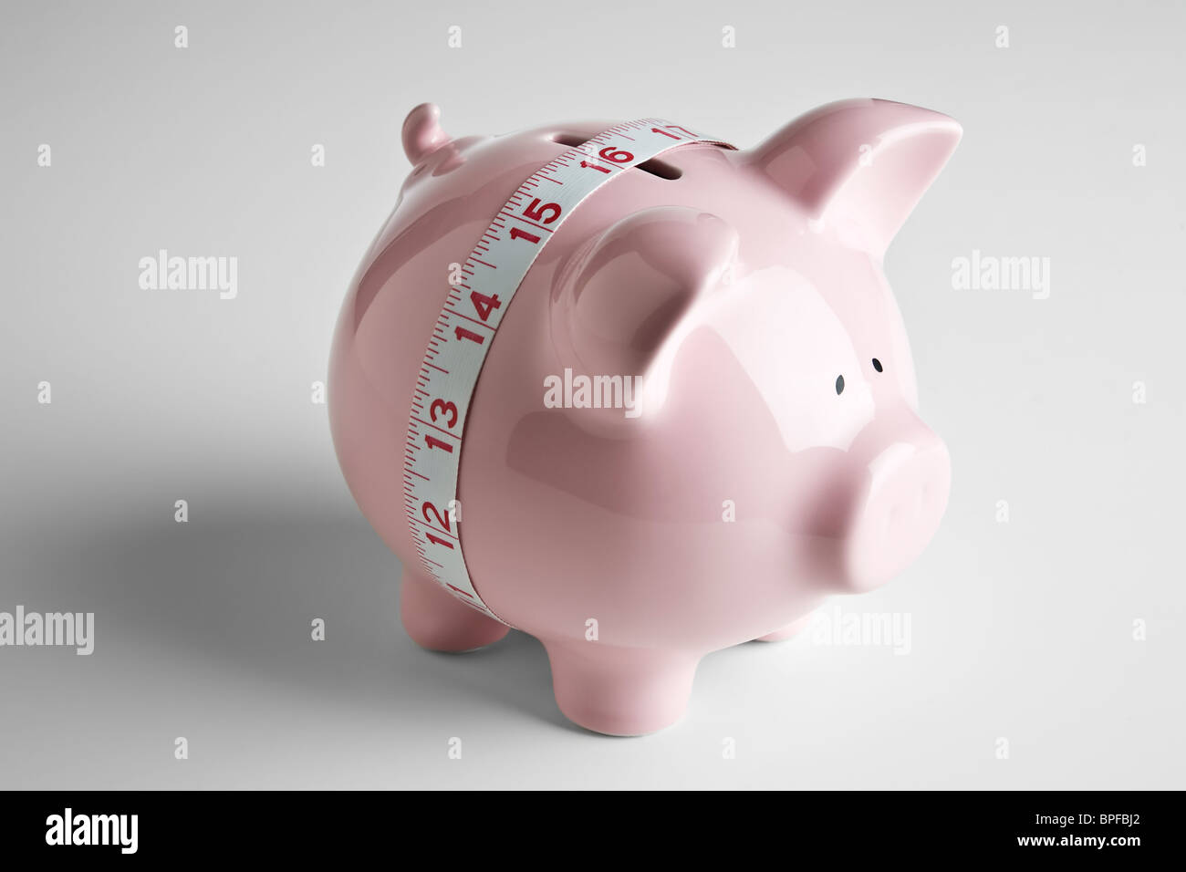 Maßband um die Mitte des ein Sparschwein Stockfoto