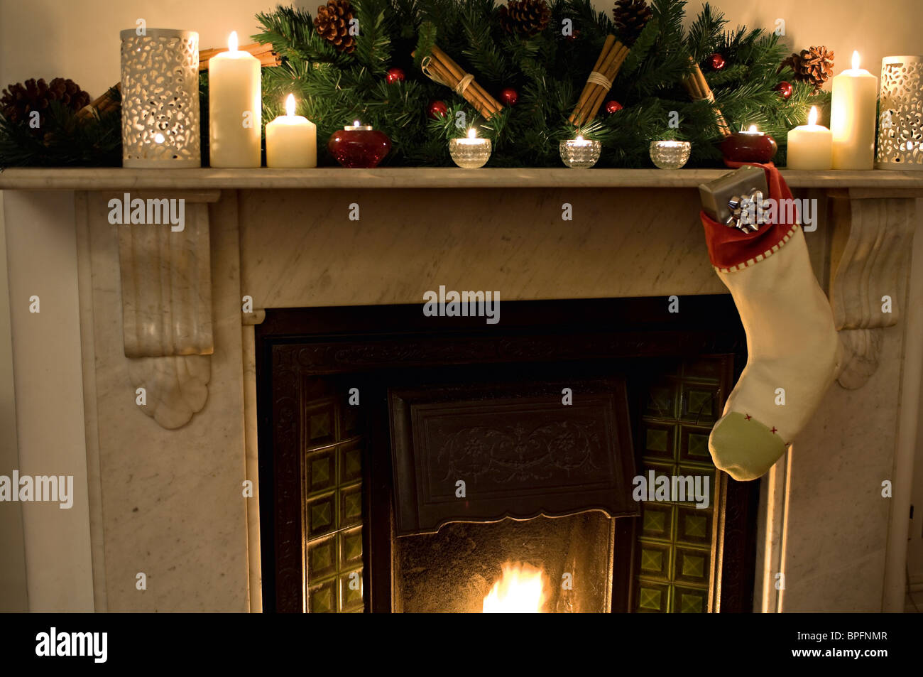 Weihnachts-Strumpf voller Geschenke über Kamin. Stockfoto