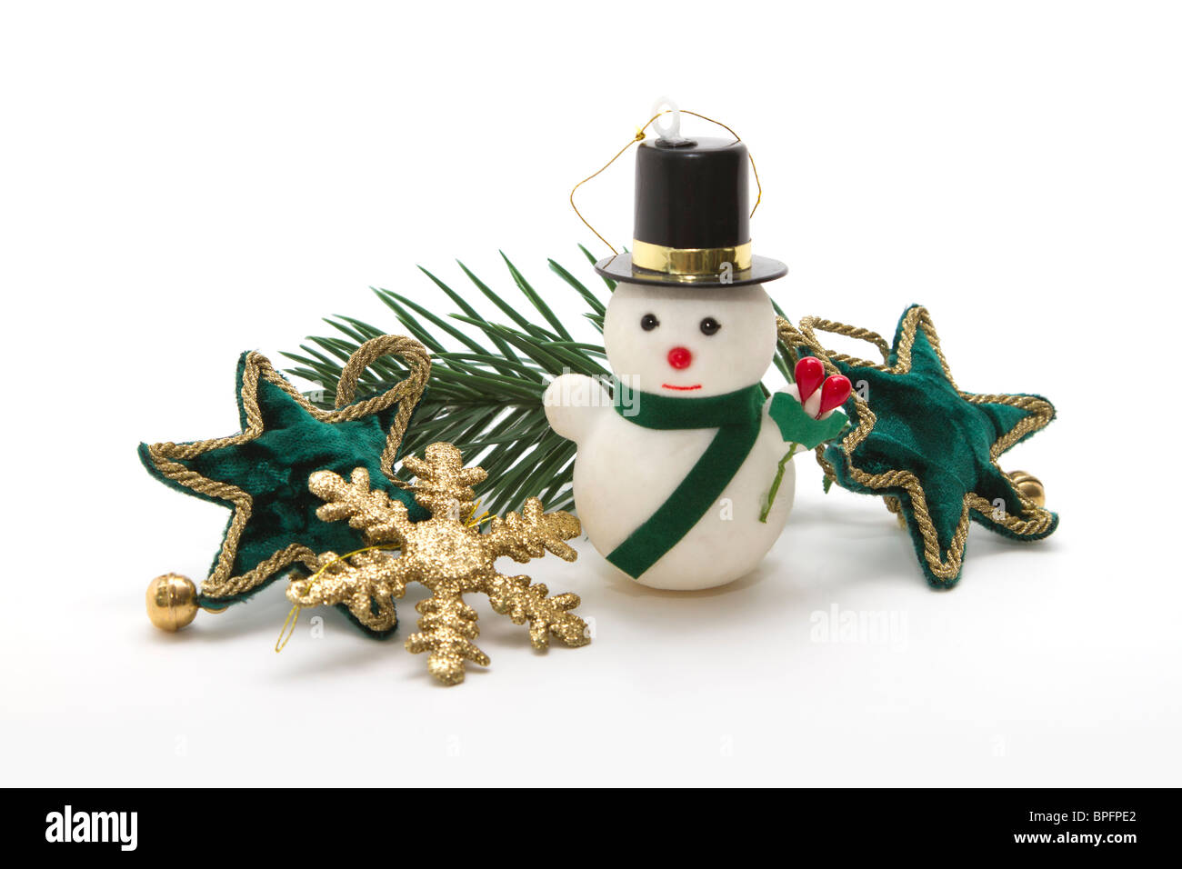 Eine Anordnung von kleinen hübschen Weihnachtsschmuck auf weißem Hintergrund. Grünem Samt Sterne, gold Schneeflocke und einen Schneemann Stockfoto