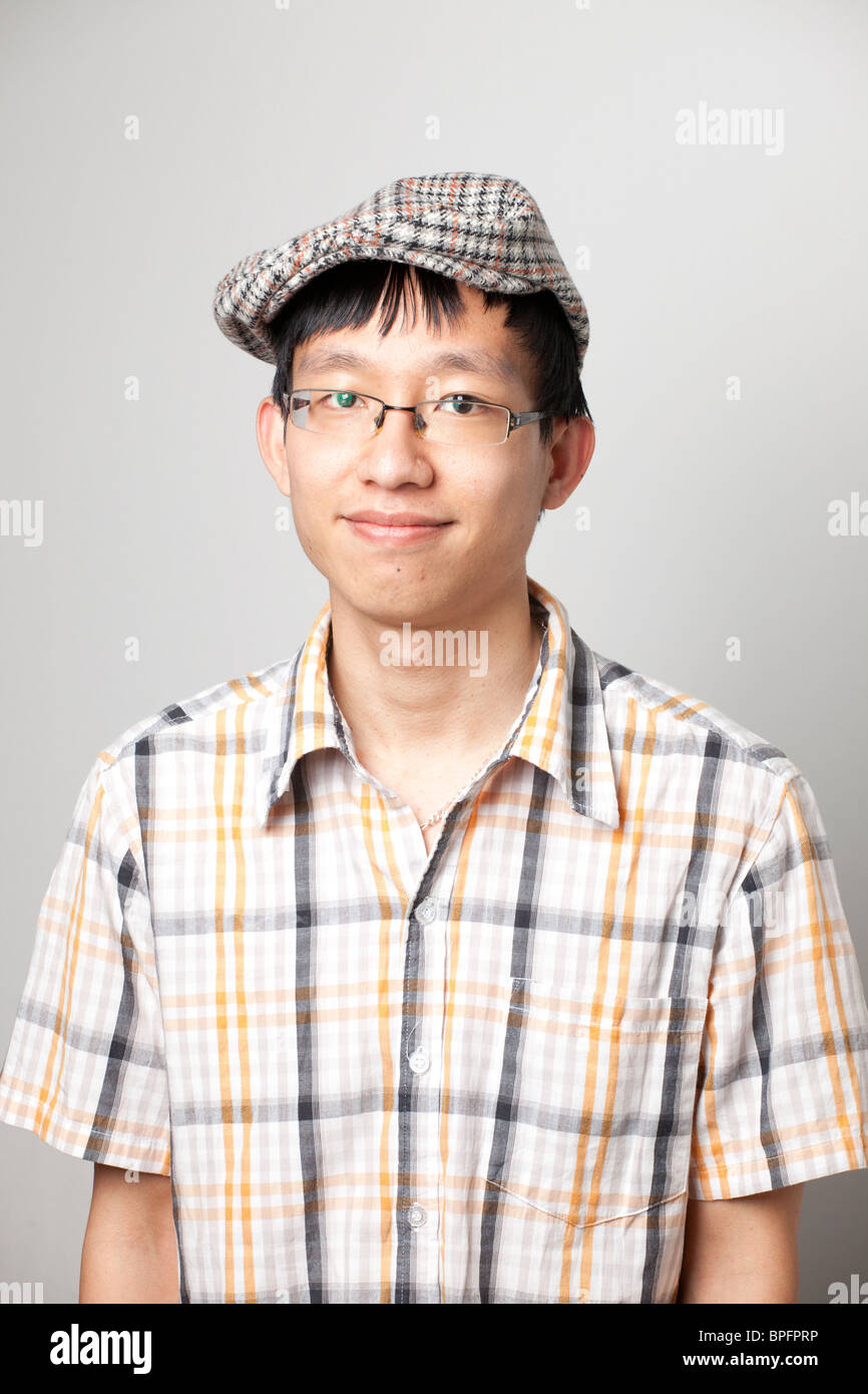 Porträt eines jungen Mannes mit angenehmem Ausdruck, der eine karierte Mütze und ein kariertes Hemd trägt Stockfoto