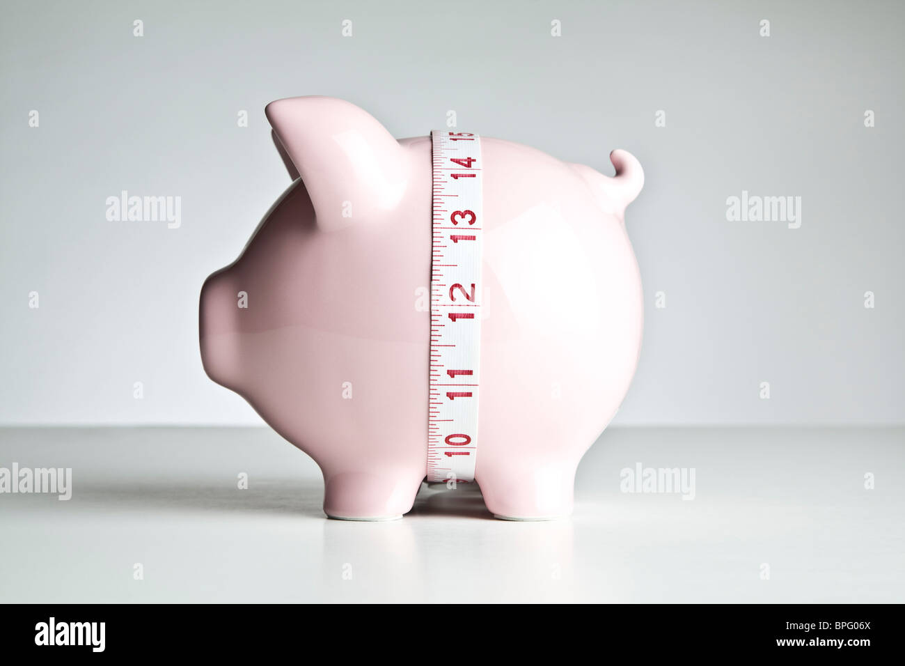 Maßband um die Mitte des ein Sparschwein Stockfoto