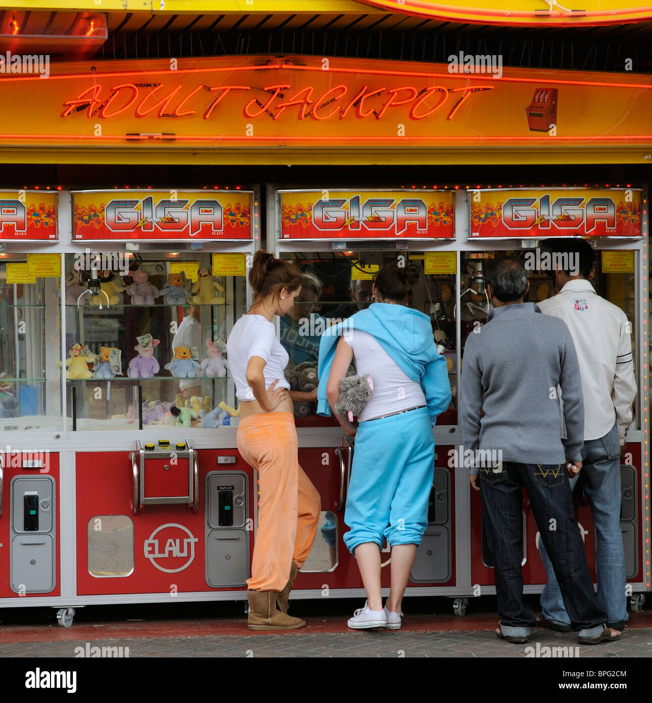Seaside Amusement Arcade-Maschinen Kunden versuchen, flauschige Spielzeug mit angehängten Banknoten zu gewinnen Stockfoto