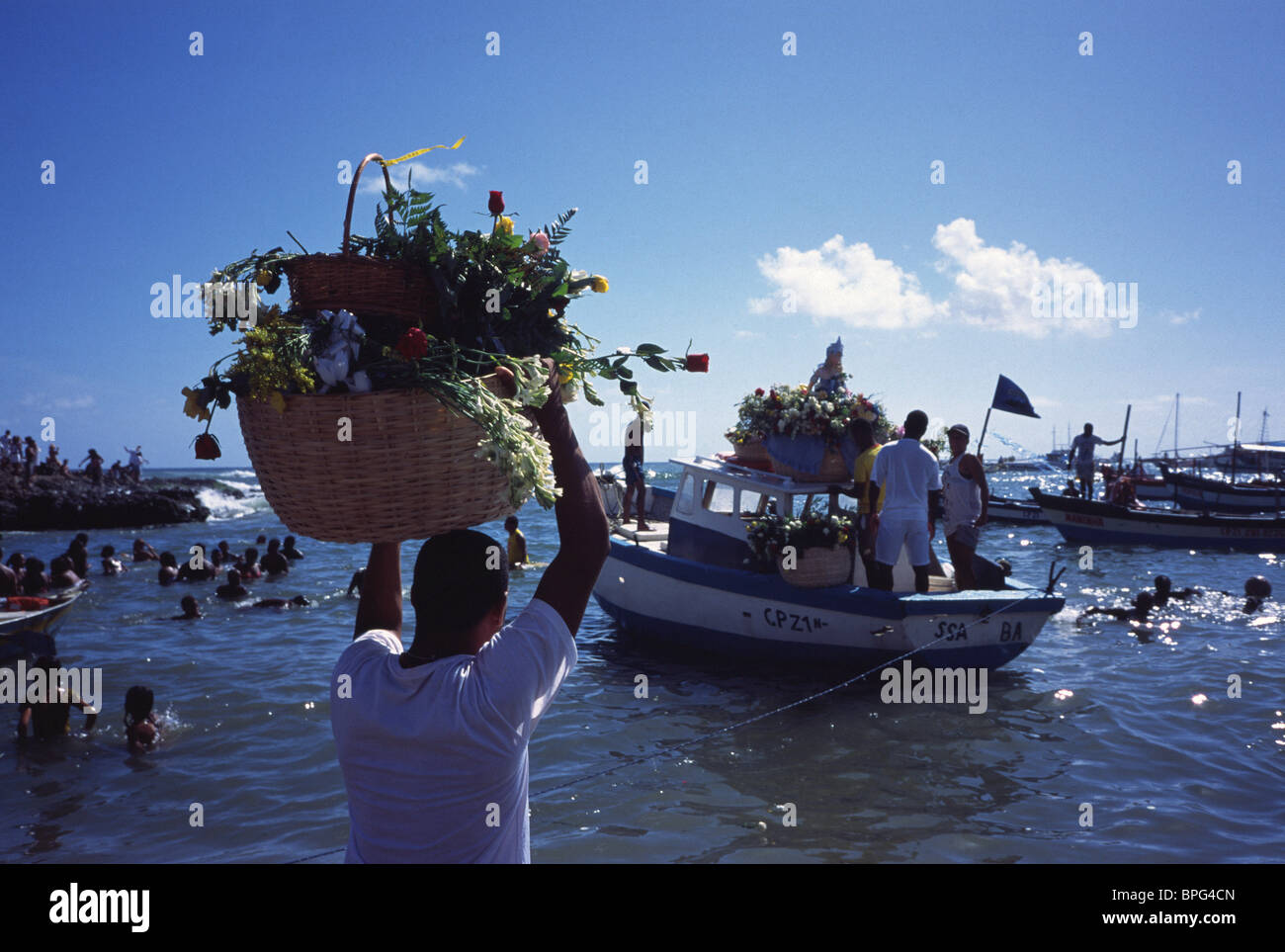 Mann, der Blumen in einem Korb auf dem Kopf für das Yemanja-Festival, Salvador Bahia, Brasilien, trägt Stockfoto