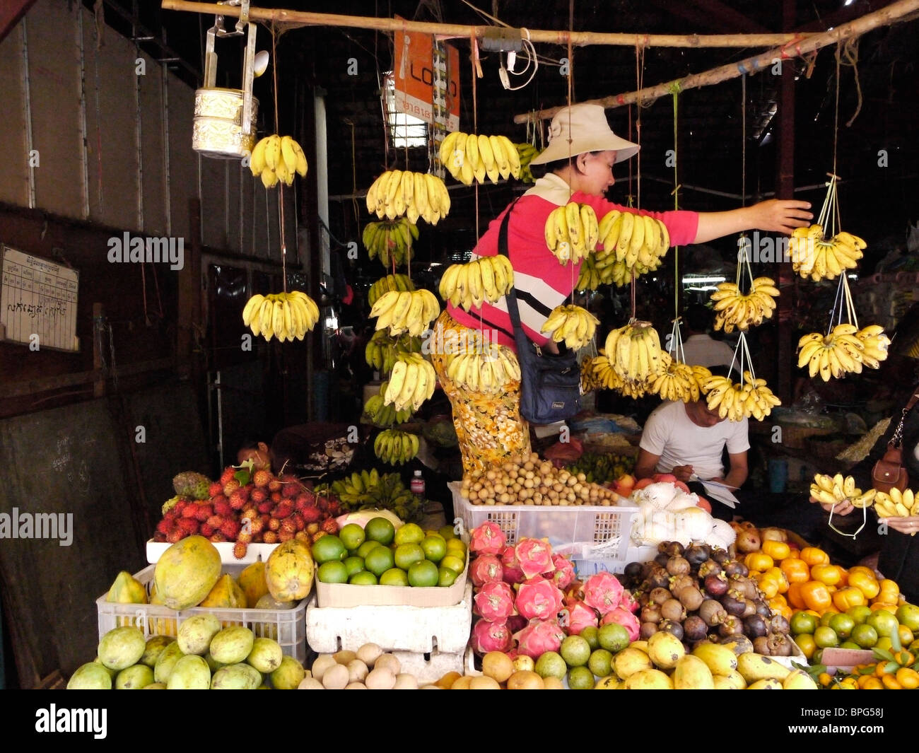 Frau am Marktstand Verkauf von Bananen und frischen Früchten, Phnom Phen Kambodscha Dezember 2009 Stockfoto