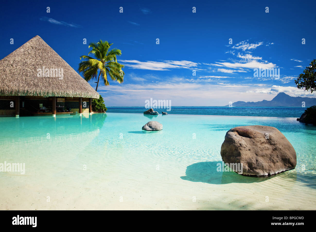 Infinity-Pool mit künstlich angelegten Strand und tropischen Ozean Stockfoto