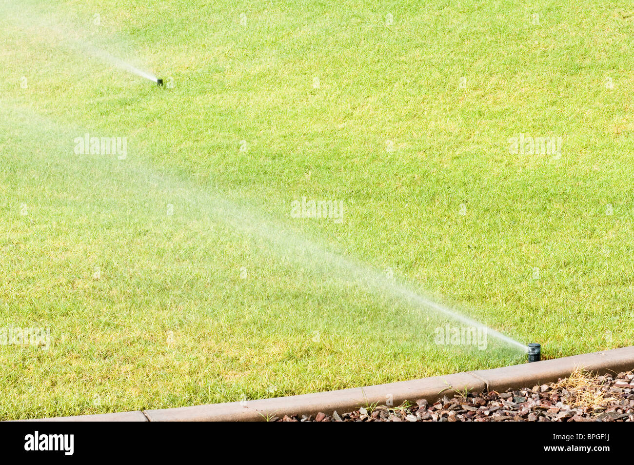 Eine automatische Bewässerungsanlage wird verwendet, um den Rasen in einem Stadtpark in Arizona zu Wasser. Stockfoto