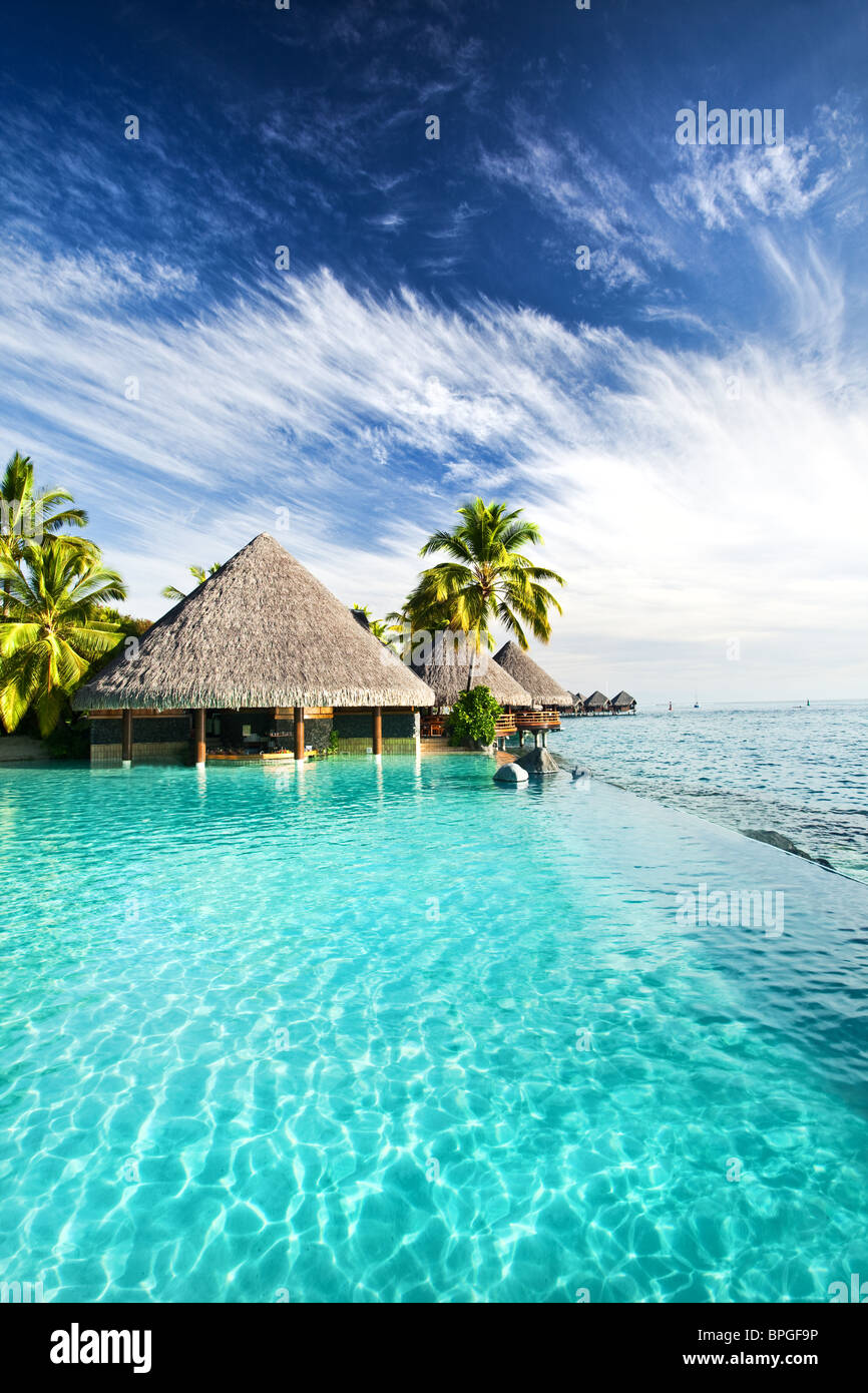 Infinity-Pool mit künstlich angelegten Strand und tropischen Ozean Stockfoto