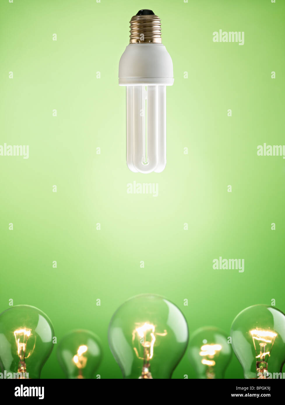 Leuchtstoff Glühlampe über große Gruppe von Kunstlicht auf grünem Hintergrund. Vertikale Form, Textfreiraum Stockfoto
