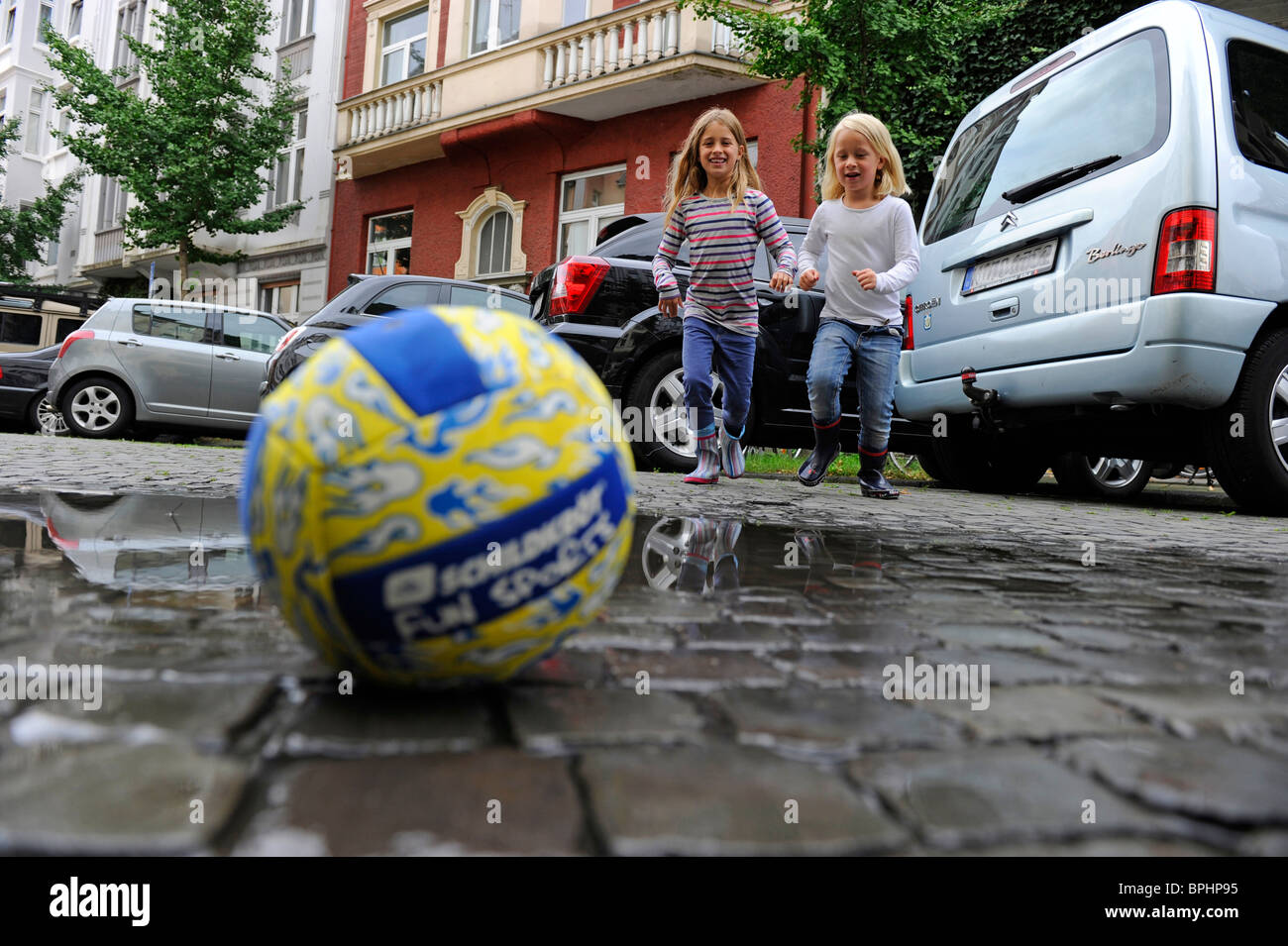 Zwei Mädchen spielen mit einem Ball in der Stadt. Stockfoto