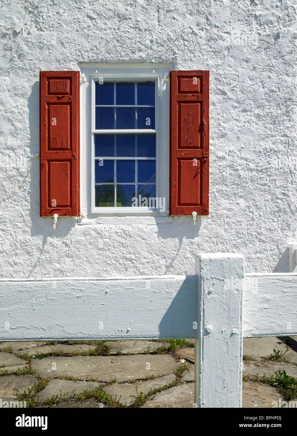 Alte Fenster mit roten Fensterläden & weißem Stuck Wand Stockfoto